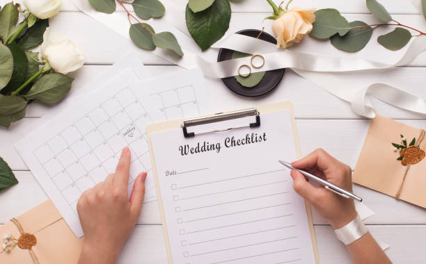 istock Woman writing wedding items in checklist for planning budget 1174436597