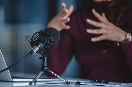 Cropped shot of an unrecognizable businesswoman sitting alone and making hand gestures during a broadcasting in her office