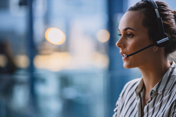 Providing you with 24/7 support Cropped shot of an attractive young businesswoman wearing a headset and sitting alone in her office call center stock pictures, royalty-free photos & images