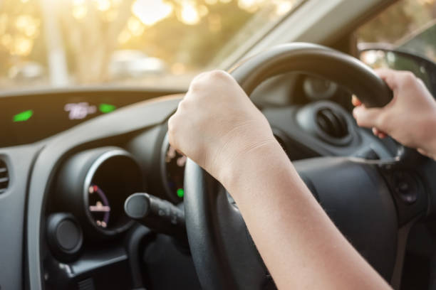 manos de mujer en el volante del coche - aprender a conducir fotos fotografías e imágenes de stock