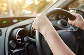 istock Woman's hands on car steering wheel 1174438394