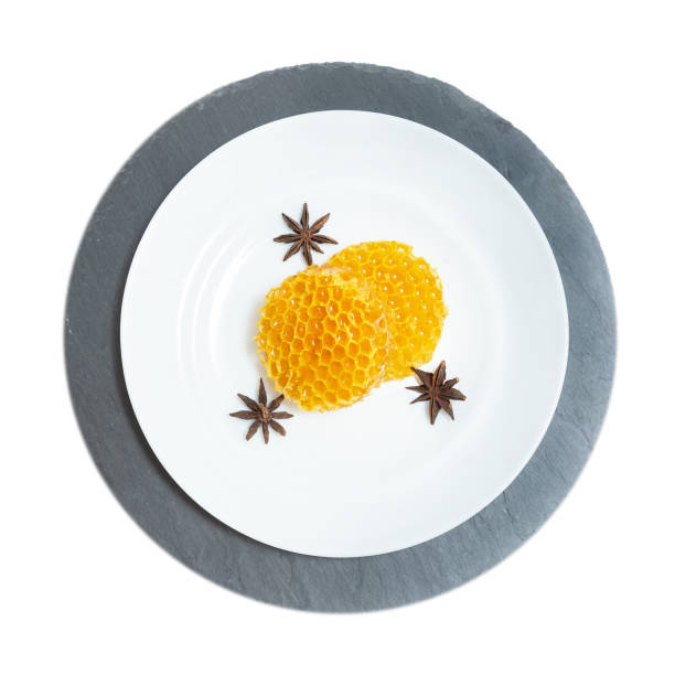 istock Round honeycombs lie on a plate on a white wooden background. 1174439667