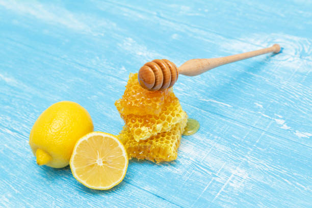 istock Honeycombs and lemon lie on a blue wooden background. 1174439674