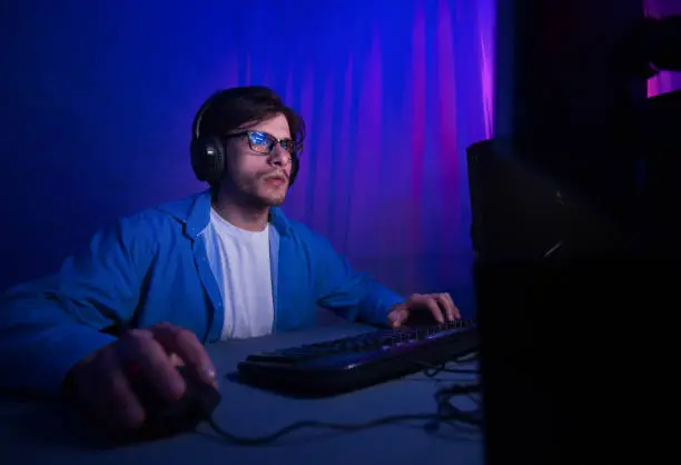 Professional gamer playing in first-person shooter video game on personal computer