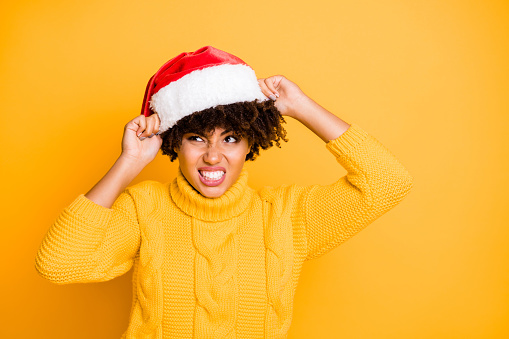 Close-up portrait of her she nice attractive mad angry unsatisfied evil wavy-haired girl putting santa outfit on expressing unpleasant isolated over bright vivid shine vibrant yellow color background