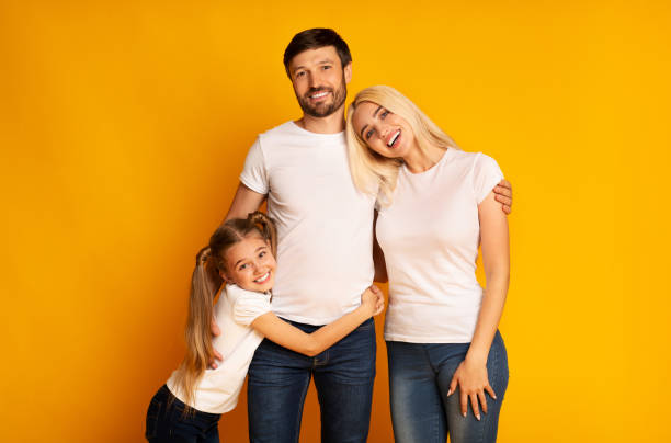 istock Happy Family Hugging Posing Over Yellow Background 1174440491