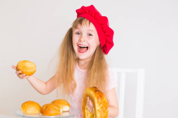 istock little girl face, red hat, baking bread, close up 1174441194