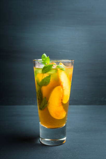 istock Tasty peach tea in glass on the rustic background 1174441274