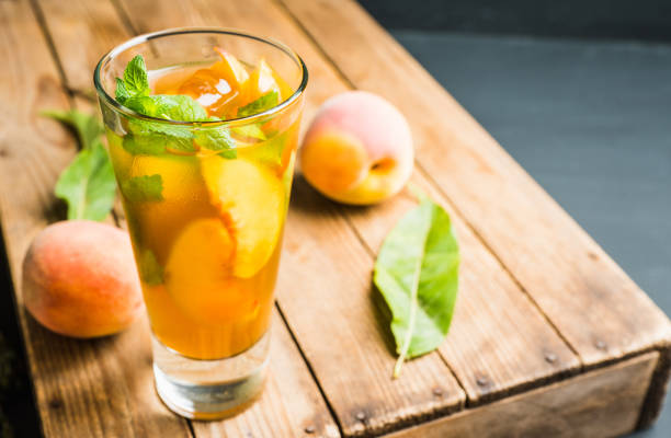 Tasty peach tea in glass on the rustic background. Selective focus. Shallow depth of field.