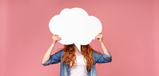 istock Girl holding empty speech bubble in front of her head 1174442898