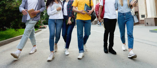 студенты колледжа в кампусе средней школы ходьба во время перерыва - university education walking teenage girls стоковые фото и изображения