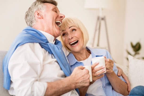 istock Happy senior couple enjoying tea and laughing 1174444360
