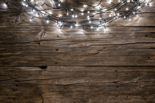 istock Empty rustic wooden table with Christmas string lights at the top border 1174444611