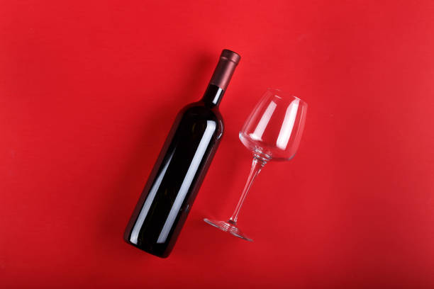 butelka wina i puste szkło na czerwonym tle - wine cork white wine grape zdjęcia i obrazy z banku zdjęć