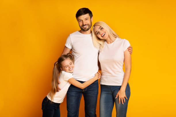 istock Loving Parents And Daughter Embracing Standing In Studio 1174445728