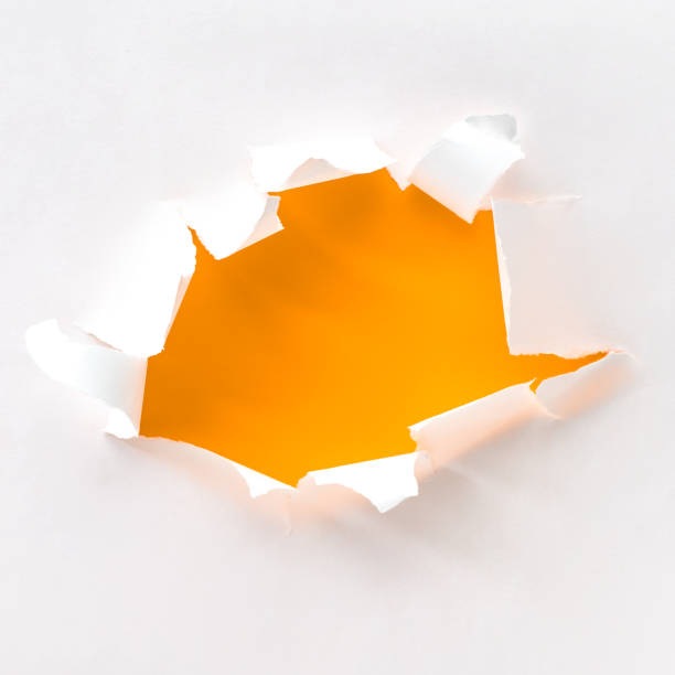 istock Teared paper hole in white paper over orange, square composition 1174445761