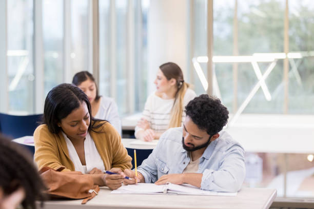 istock Mid adult man receives help from Chemistry tutor at library 1174446113