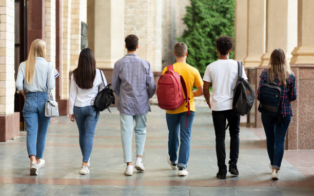 istock College friends walking together in hall after studies 1174446536