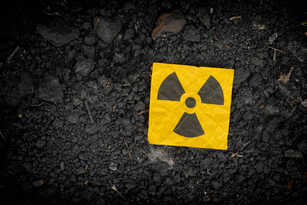 Radiation warning sign on soil background Radiation warning sign on soil background. Close up. radioactive contamination photos stock pictures, royalty-free photos & images
