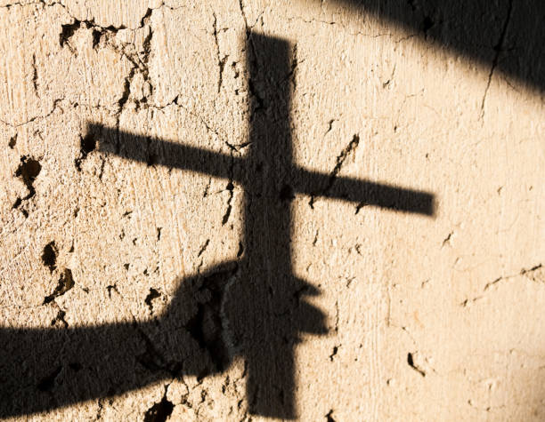 istock Shadow of the hand holding a cross 1174448390