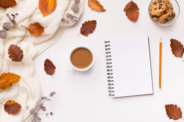 istock Notebook with copy space, coffee and fallen leaves on white 1174449588