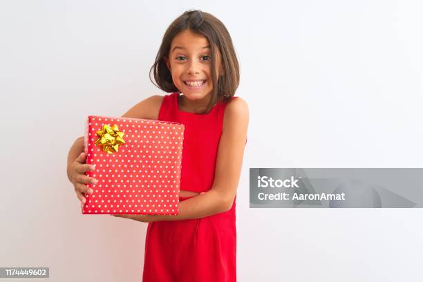 Beautiful Child Girl Holding Birthday Gift Standing Over Isolated White Background With A Happy Face Standing And Smiling With A Confident Smile Showing Teeth Stock Photo - Download Image Now