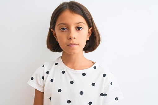 Young beautiful child girl wearing casual t-shirt standing over isolated white background with a confident expression on smart face thinking serious
