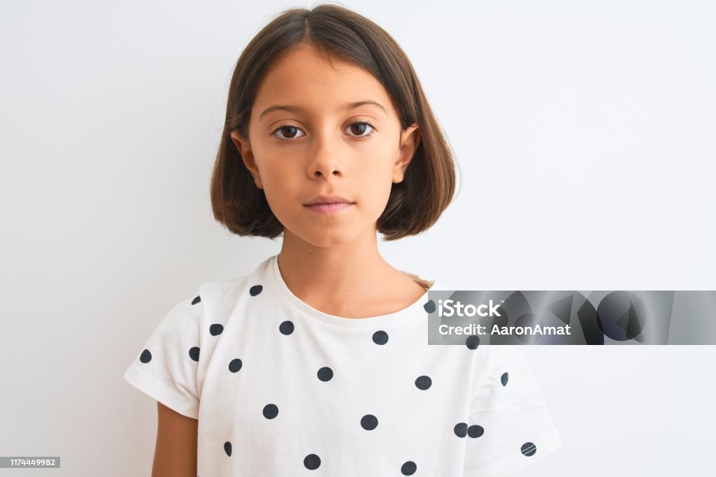 Young beautiful child girl wearing casual t-shirt standing over isolated white background with a confident expression on smart face thinking serious Child Stock Photo