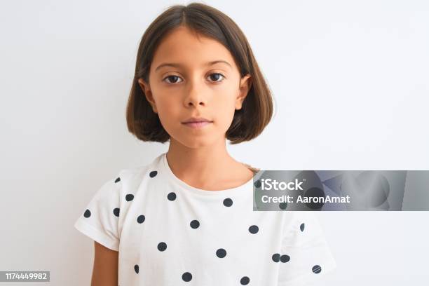 Young Beautiful Child Girl Wearing Casual Tshirt Standing Over Isolated White Background With A Confident Expression On Smart Face Thinking Serious Stock Photo - Download Image Now