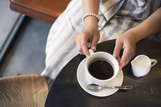 istock Young girl in a cafe with a coffee cup 1174451308