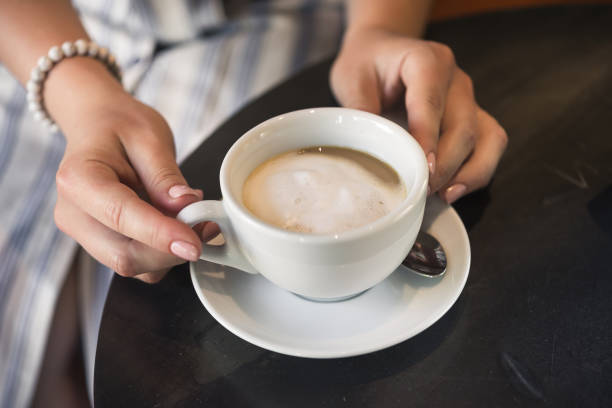 istock Young girl in a cafe with a coffee cup 1174451333