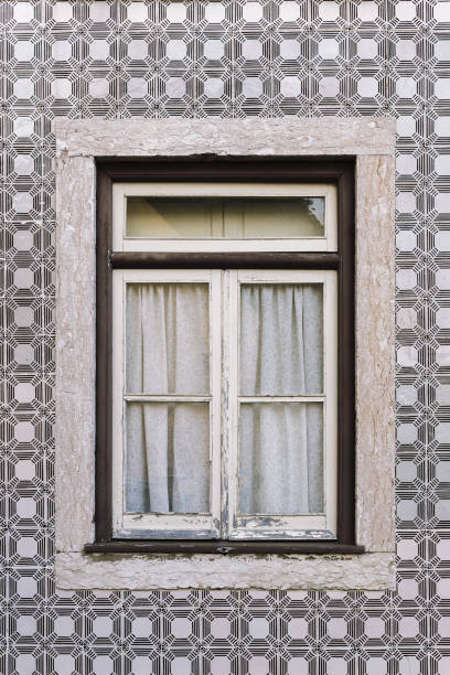 vertical photo of a typical house with vintage wooden window in an old tile facade with geometric pattern, picturesque architecture at Lisbon, Portugal