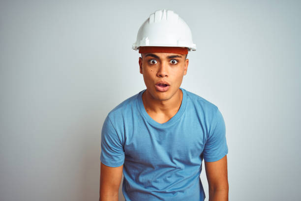 istock Young brazilian engineer man wearing security helmet standing over isolated white background afraid and shocked with surprise expression, fear and excited face. 1174457673