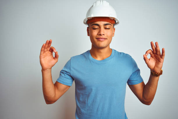 istock Young brazilian engineer man wearing security helmet standing over isolated white background relax and smiling with eyes closed doing meditation gesture with fingers. Yoga concept. 1174457696