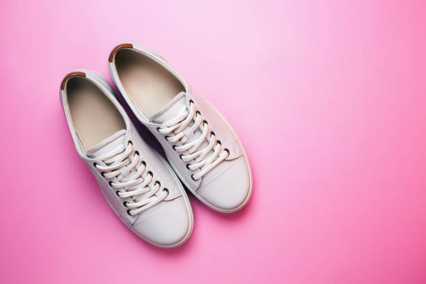 istock White trendy sneakers on pink pastel background. Front view. 1174458110