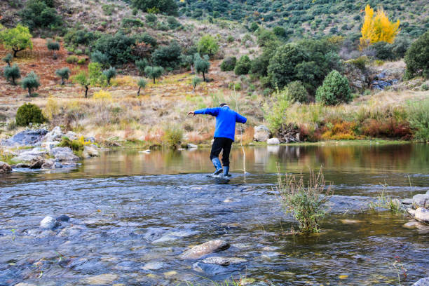 istock Man crossing the river with a stick 1174459941