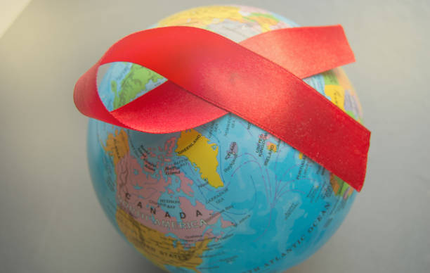 The red ribbon on the background of the globe is an international symbol of struggle, a symbol of compassion, support and hope for a future without AIDS stock photo