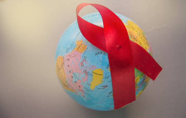 dünyanın arka planda kırmızı kurdele mücadele, şefkat, destek ve aids olmadan bir gelecek için umut sembolü uluslararası bir sembolüdür - world aids day stok fotoğraflar ve resimler