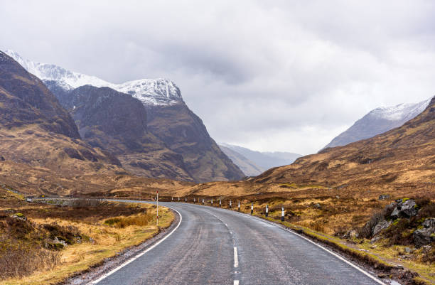 Entering Glencoe in Scotland The curving main road through the historic and famous landscape of Glencoe. lochaber stock pictures, royalty-free photos & images