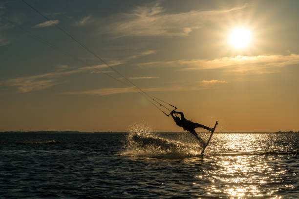 istock kitesurfer doing unhooked backroll in sunset with sunstar and beautiful silhouette 1174466986