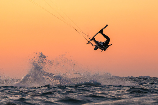 Kitesurfer doing unhooked tricks in beautiful sunset conditions and nice colors