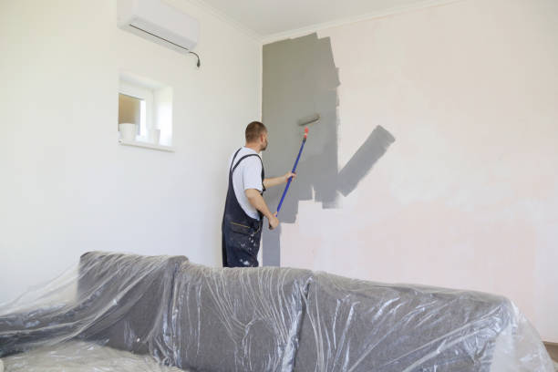 istock Man painting with gray paint over a white wall 1174467406