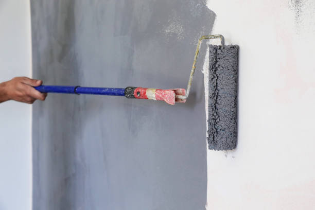 istock Paint roller. Painting with gray paint over a white wall 1174467617
