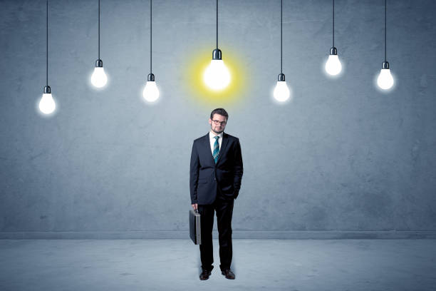 istock Businessman standing uninspired with bulbs above 1174471760