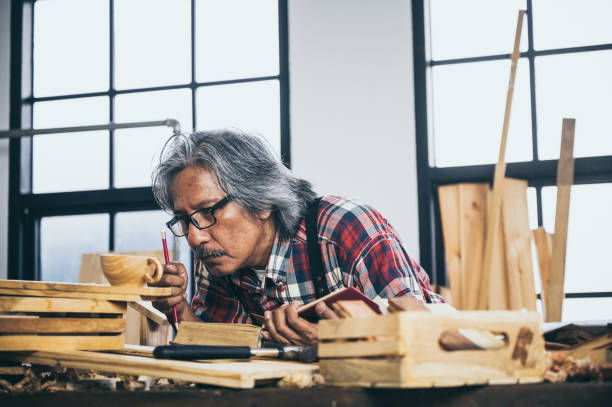 istock Background image of woodworking workshop: carpenters work table with different tools and wood cutting stand, vintage filter image 1174472322