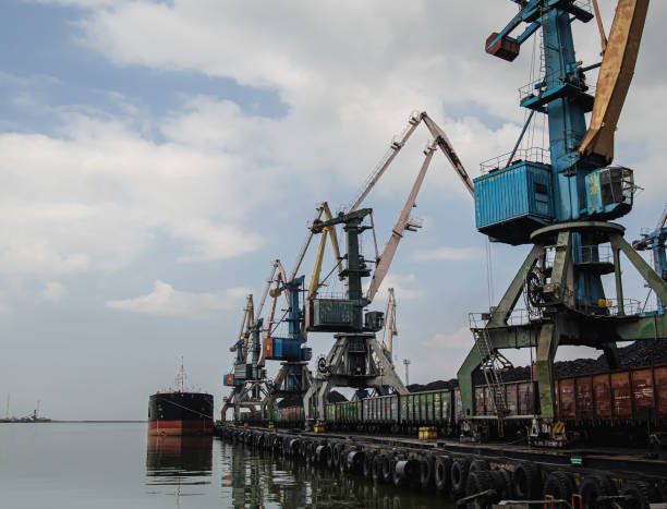 istock unloading of a tanker and loading into a freight train at a port of coal using powerful and large port cranes. Overall plan 1174472371