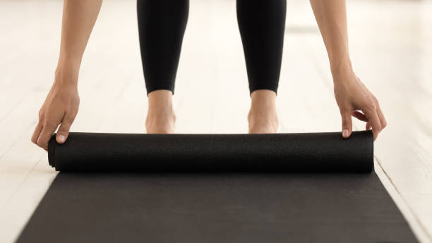 istock Close up view woman hands rolling mat after yoga practice 1174472516