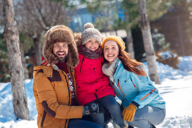 istock Winter vacation. Family time together outdoors sitting hugging smiling happy 1174473473