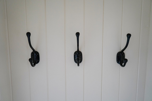 Black coat hooks on a white wall