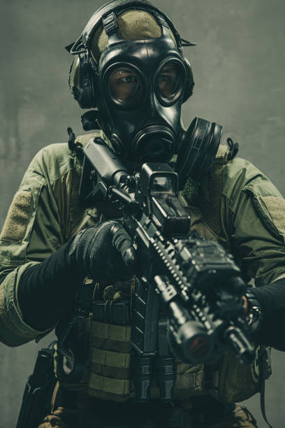 istock Special unit soldier with gasmask and tactical equipment is holding assault rifle 1174475217